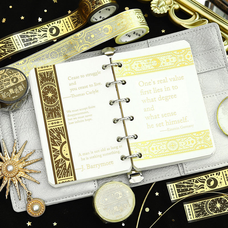 Decorative notebook with gold text and designs on a black background with decorative items.