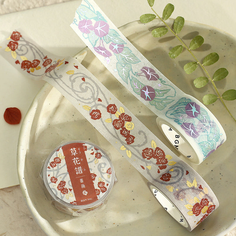 Two rolls of decorative tape with floral designs on a textured surface.