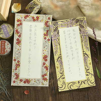 Two decorative cards with floral designs on a wooden surface.