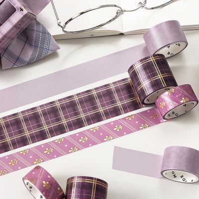 Purple washi tape with plaid and floral patterns on a white surface.