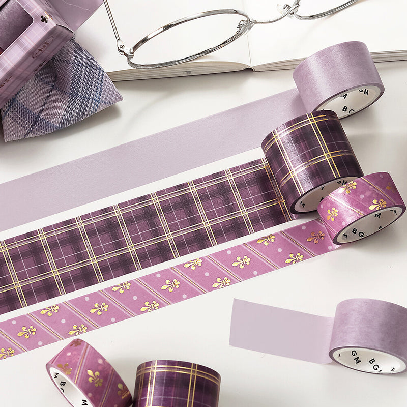 Purple washi tape with plaid and floral patterns on a white surface.