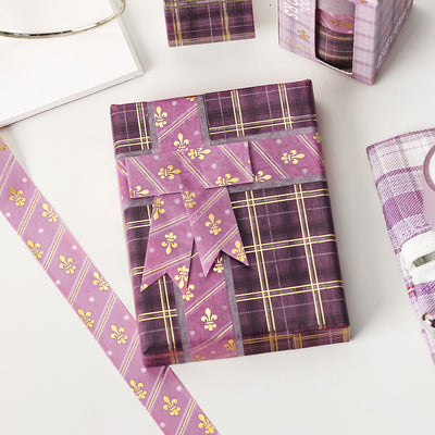 Purple plaid gift wrap with decorative patterns on a white surface