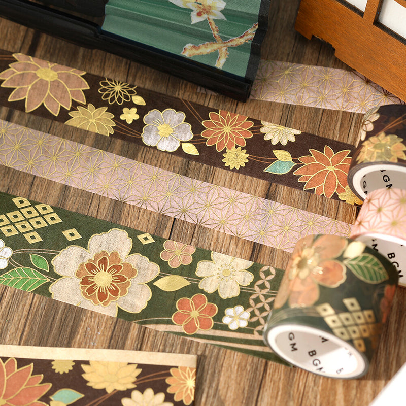 Decorative washi tape with floral and geometric patterns on a wooden surface.