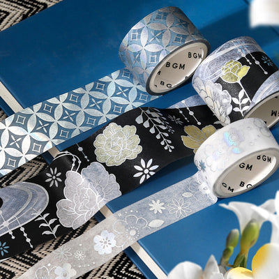 Decorative tape rolls with floral and geometric patterns on a blue surface.