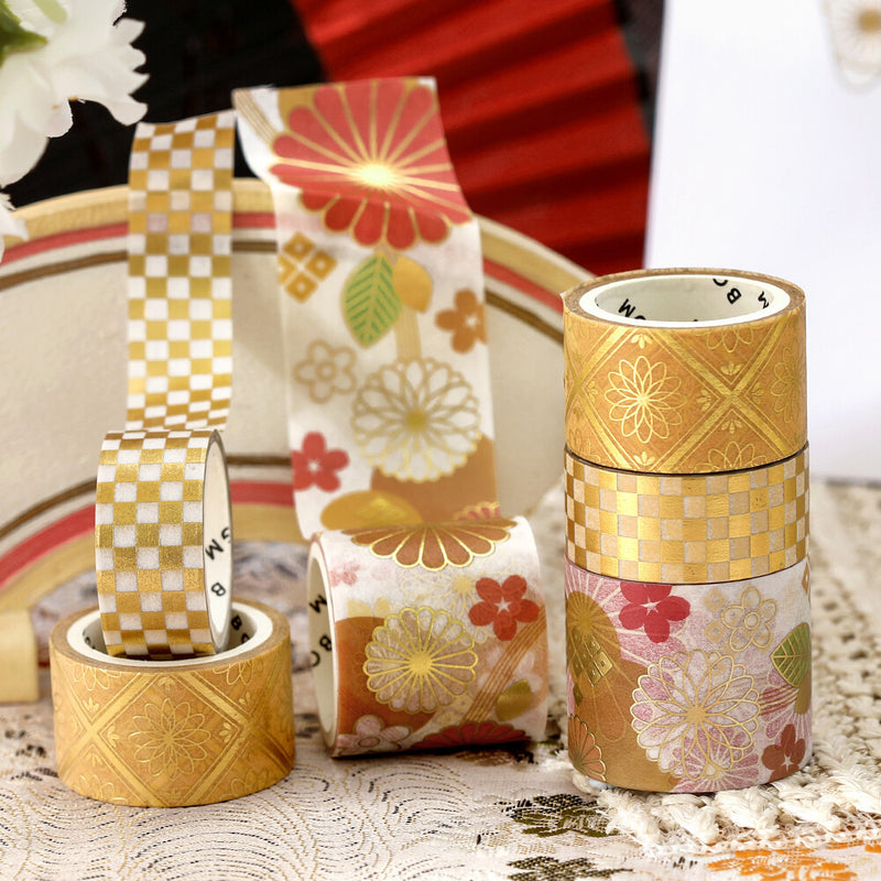 Decorative tape rolls with floral and geometric patterns on a textured surface.