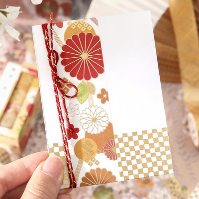 Decorative card with floral patterns held by a hand against a blurred background