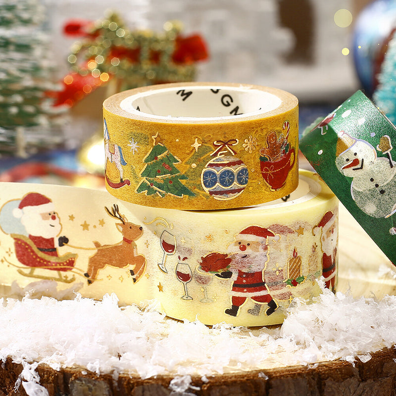 Three rolls of decorative tape with Christmas designs on a wooden surface.