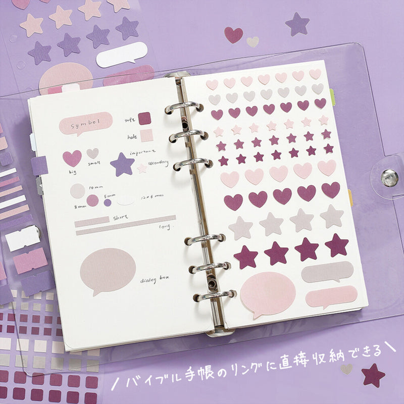 Open planner with decorative stickers on a purple background