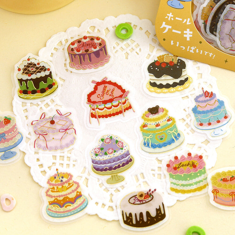 Colorful cake-shaped stickers on a decorative sheet with a yellow background
