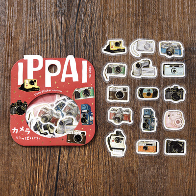 Set of camera-themed stickers with 'IPPAI' packaging on a wooden surface