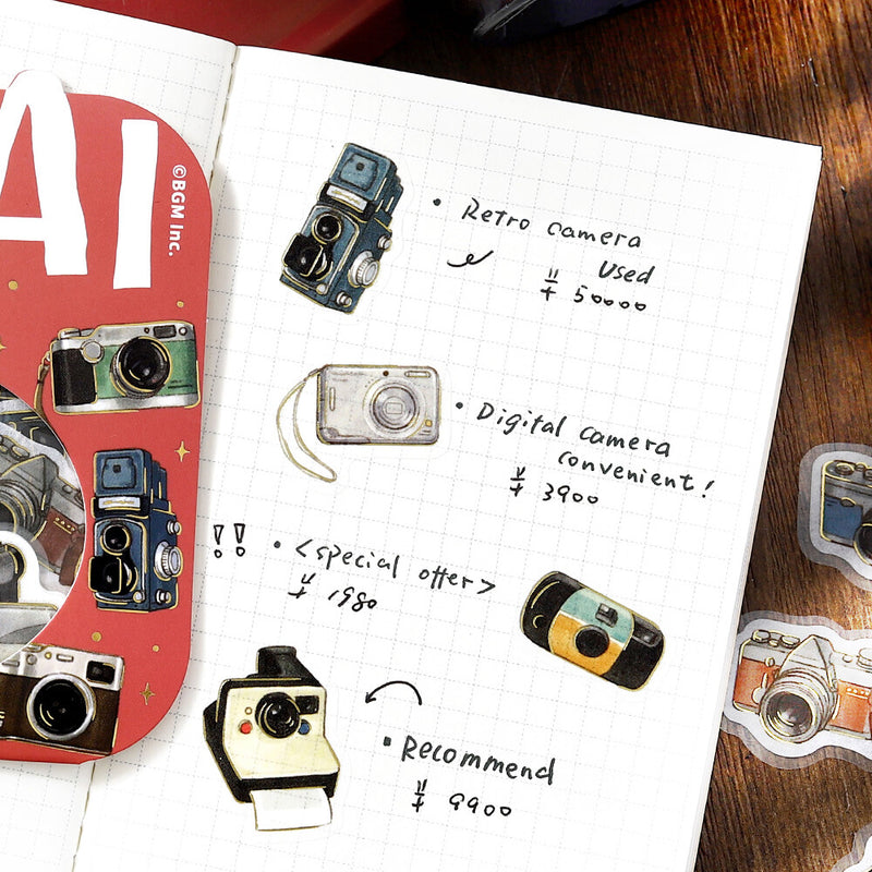 Notebook with illustrations of cameras and text on a wooden surface
