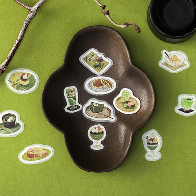 Decorative tray with food-themed stickers on a green surface