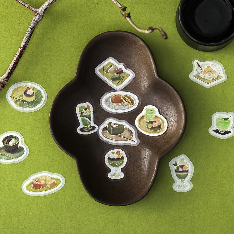 Decorative tray with food-themed stickers on a green surface