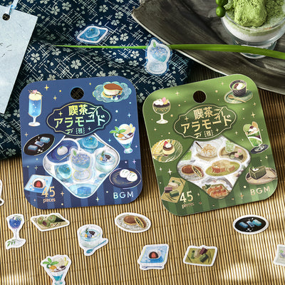Two packages of decorative stickers with food illustrations on a wooden surface.