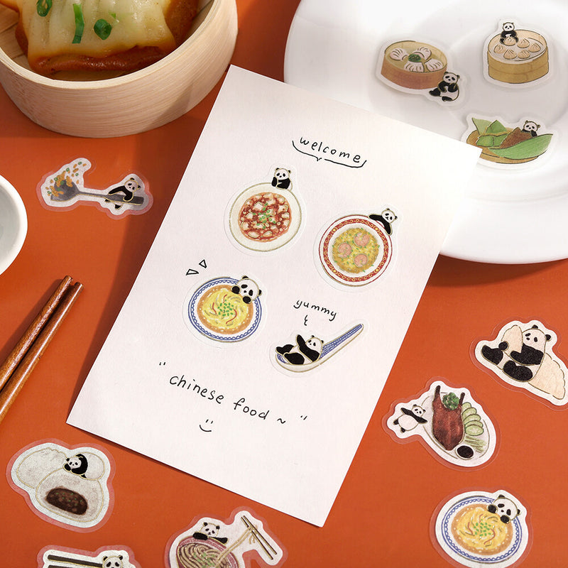 Stickers featuring panda bears and Chinese food on a red surface with a sheet of paper.