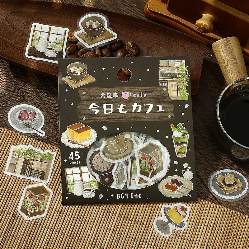 Pack of stickers with coffee-themed illustrations on a wooden surface with coffee beans and a cup.