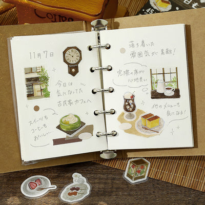 Open notebook with illustrated pages on a wooden surface