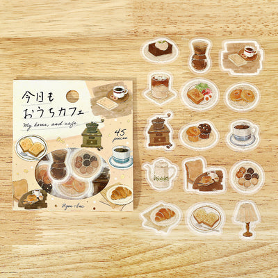 Set of illustrated stickers on a wooden surface with a packaging sheet.