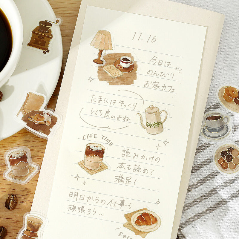 Notebook page with coffee-themed illustrations and text on a wooden surface with a cup of coffee.