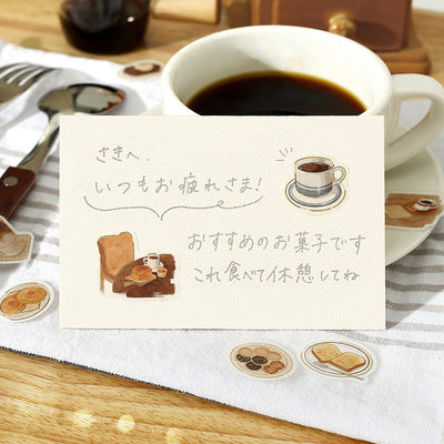 Cup of coffee with a card and illustrations on a wooden table