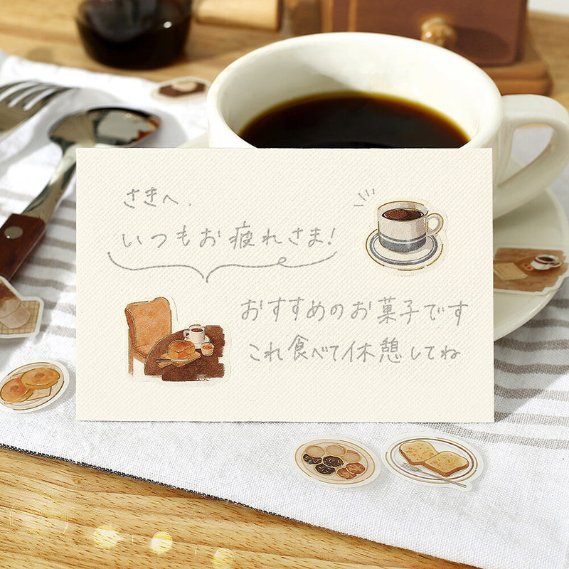 Cup of coffee with a card and illustrations on a wooden table