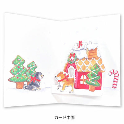 Christmas-themed card with gingerbread house, trees, and dogs on a white background