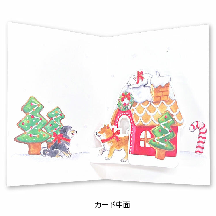 Christmas-themed card with gingerbread house, trees, and dogs on a white background