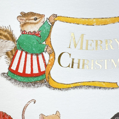 Illustration of a squirrel holding a 'Merry Christmas' banner with gold text on a white background.