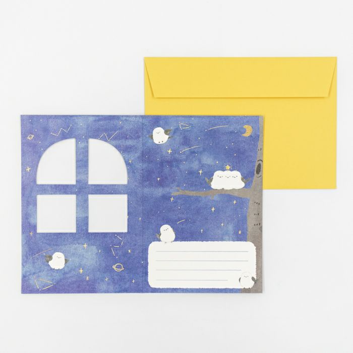 Greeting card with a blue night sky design, yellow envelope, and white envelope on a white background