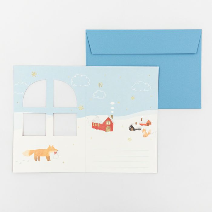 Greeting card with a blue envelope featuring illustrations of a fox, house, and sailboat on a snowy landscape.
