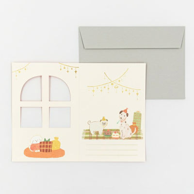 Greeting card with cartoon dogs by a window and envelope on a white background