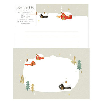 Stationery with winter scene design featuring houses and trees on a snowy background.